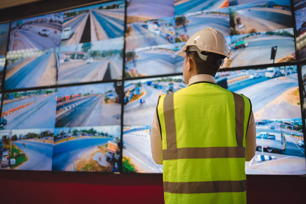 An engineer is seriously checking the condition of the CCTV camera system in an office.